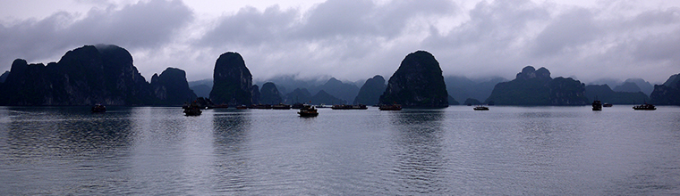 A UNESCO World Natural Heritage Site, Ha Long Bay translates to Descending Dragon Bay in Vietnamese. The Bay features a couple thousand limestone karsts and isles in various shapes and sizes. The water is very calm despite a flurry of container ships and overnight boat cruises passing through the area. Floating fishing villages and limestone caves add to the allure of the area. For both days spent on the water, we were shrouded with overcast skies, misting rain and cool temperatures. These weather conditions created a mysterious and mesmerizing effect for this photo taken in color with my Panasonic DMC-GF1 camera on the morning of the second day just before returning to the harbor. April 17, 2010. - Laurel Pfund